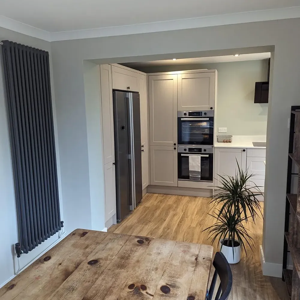 a kitchen with a table, oven and a radiator
