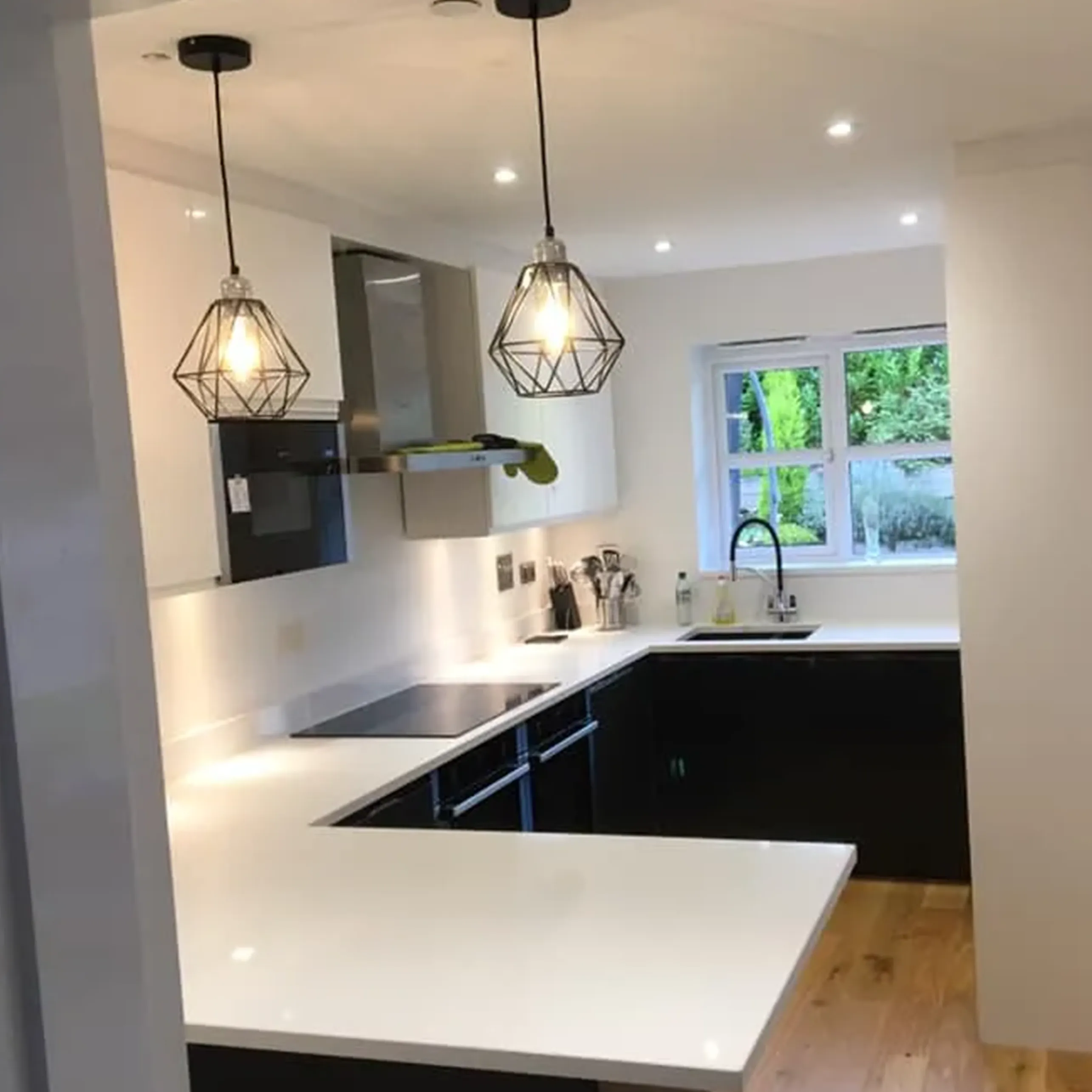 A kitchen with a white counter top next to a window.
