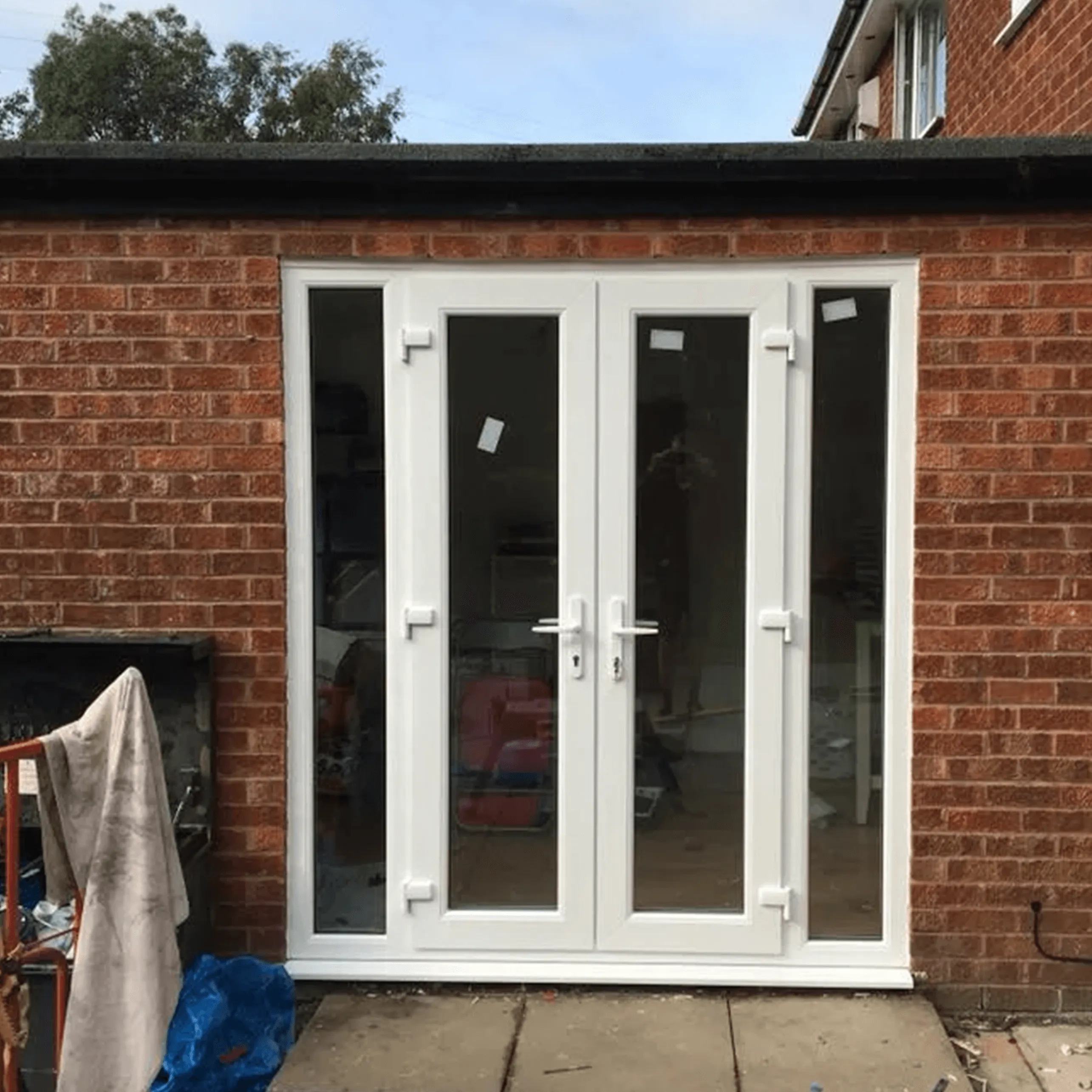 A brick building with a white double doors.