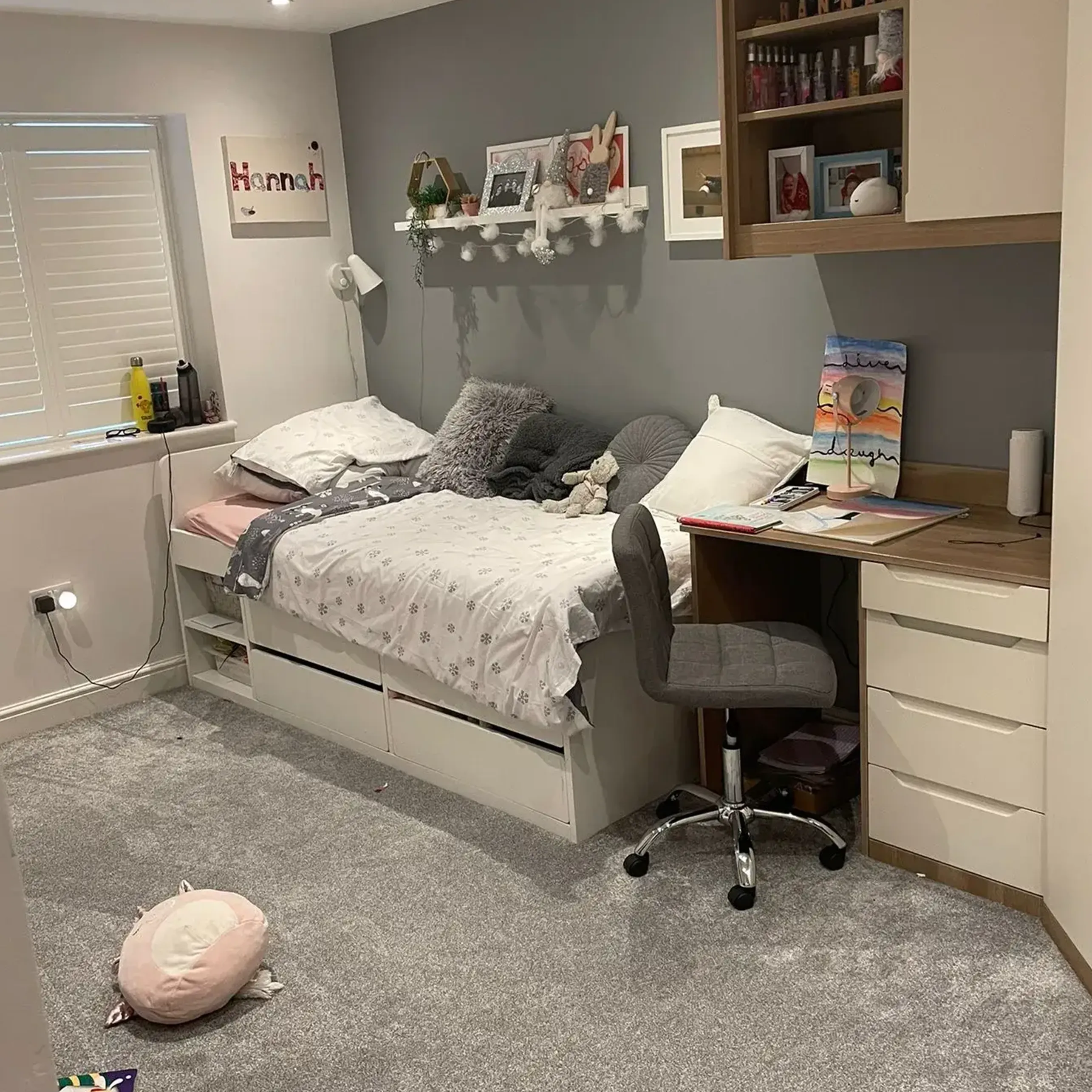 A bedroom with a bed, desk, chair and bookshelf.