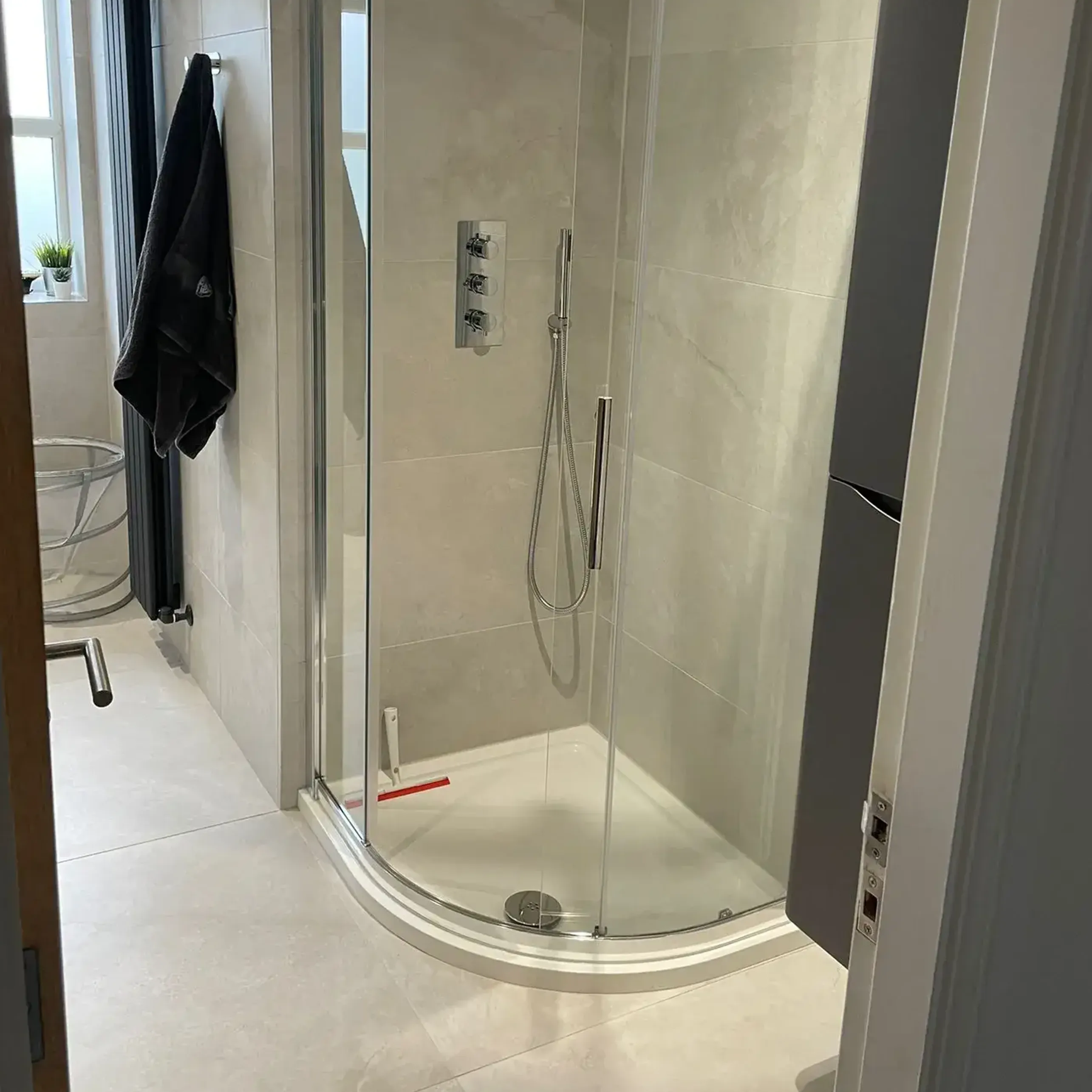 A bathroom with a walk in shower next to a toilet.