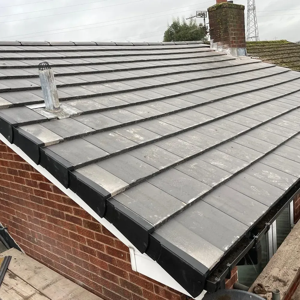a brick building with a tiled roof and a chimney