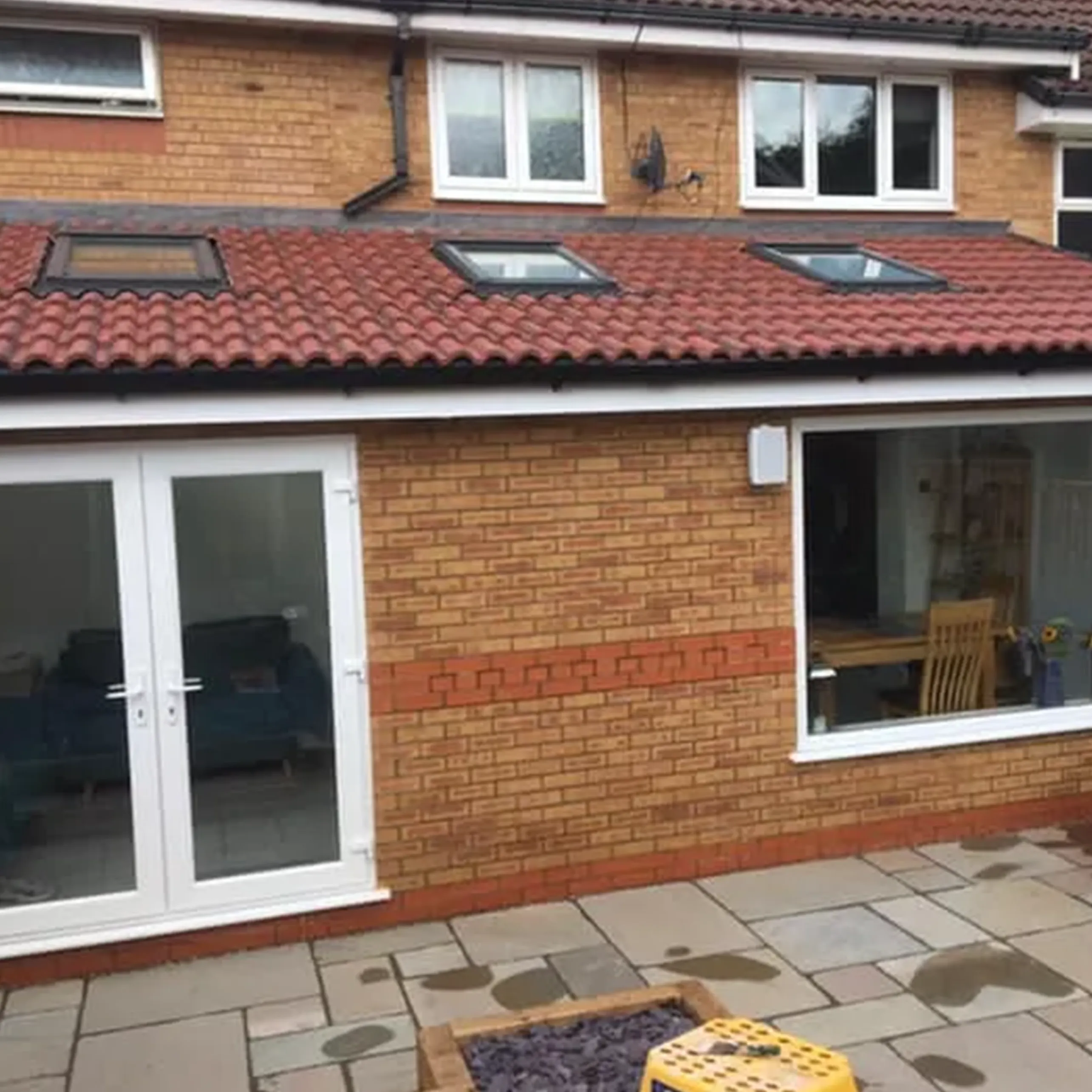 A brick house with a patio and patio furniture.