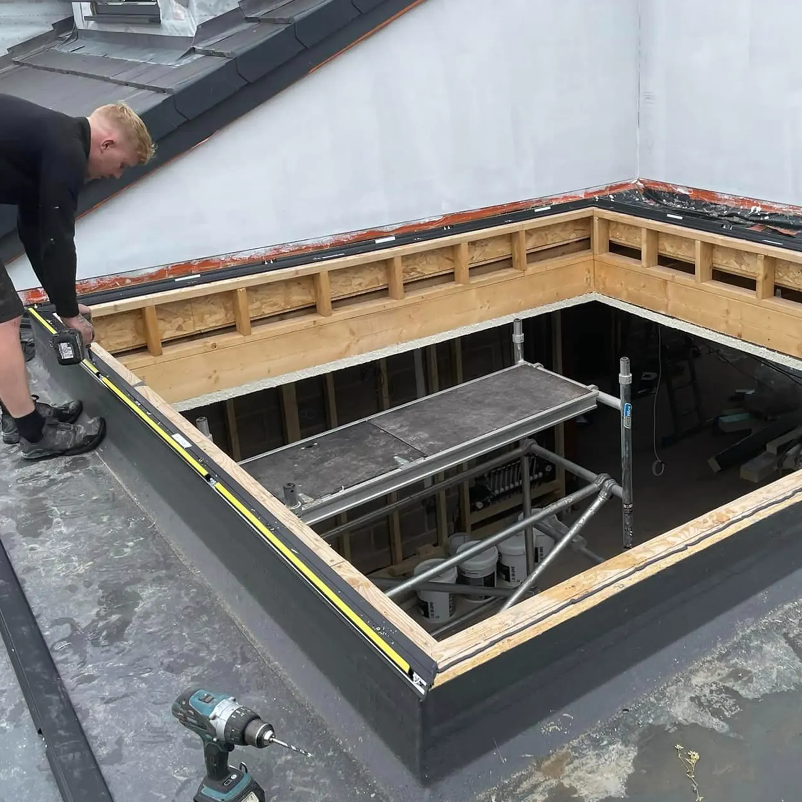 A man working on a roof with tools.