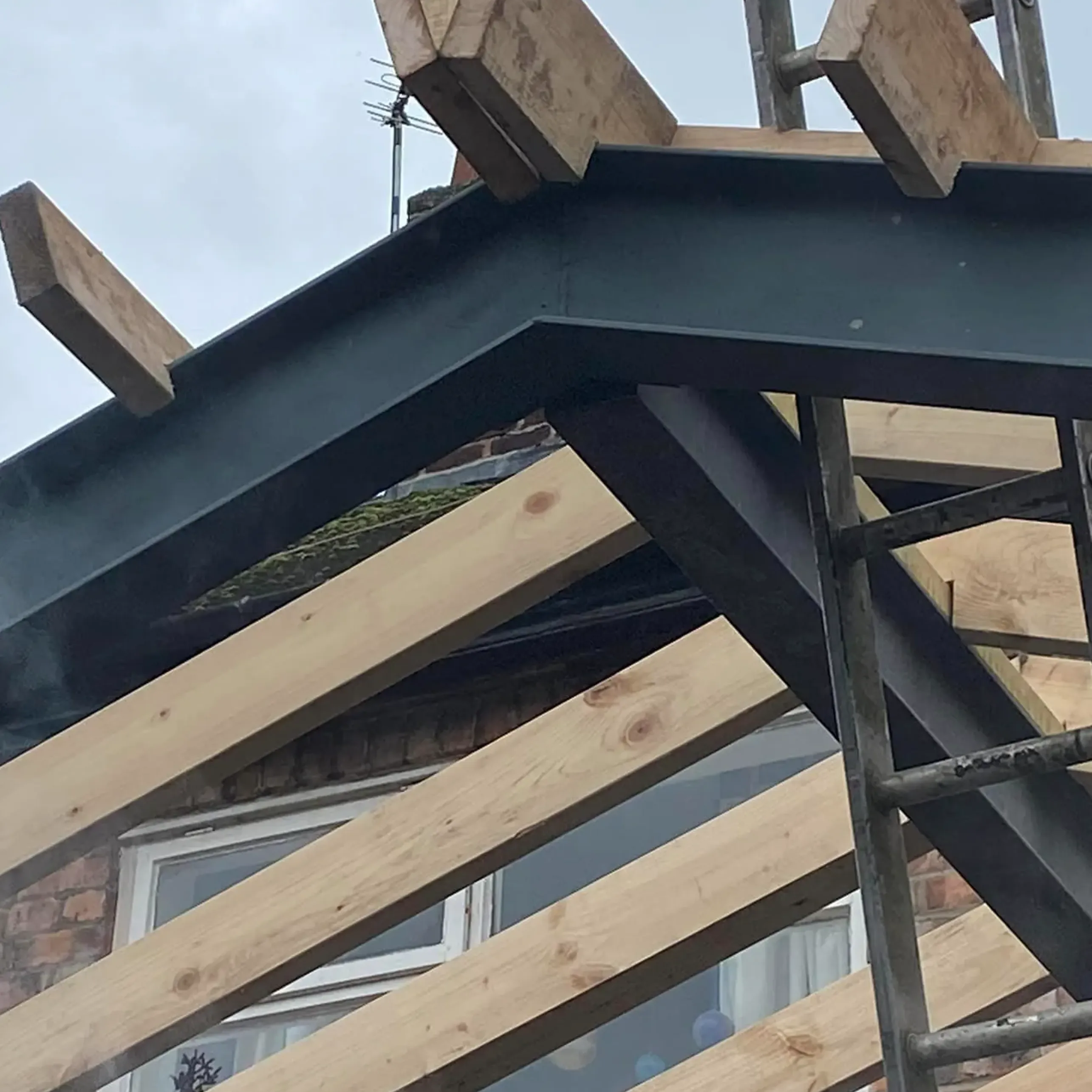 A close up of a wooden structure with a bird perched on top of it.